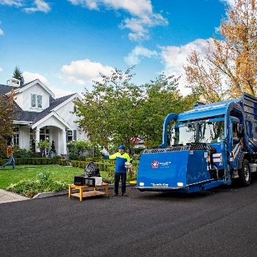 Stock photo of blue Republic truck dumping waste at a neighborhood home