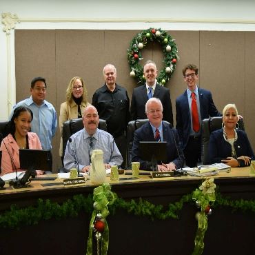 The 2022-2024 Battle Creek City Commissioners pose together behind the dais in Commission Chambers.
