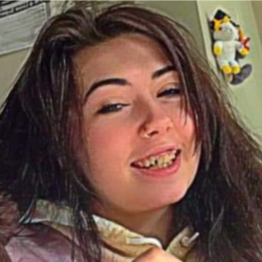 Teen white girl, long dark brown hair/eyebrows, chipped front tooth.